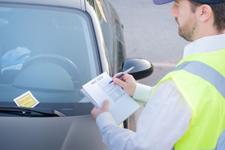 Carro sendo multado por estar estacionado em local proibido